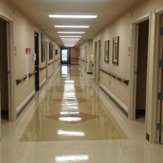 A well-lit corridor with multiple doors lining the walls, showcasing a clean and organized environment.
