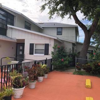 A residential house with a parking area and potted plants.