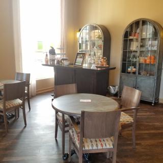 A cozy cafe interior with tables, chairs, and display cabinets.