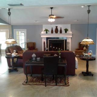 A cozy living room featuring a central fireplace, elegant furniture, and decorative lighting.