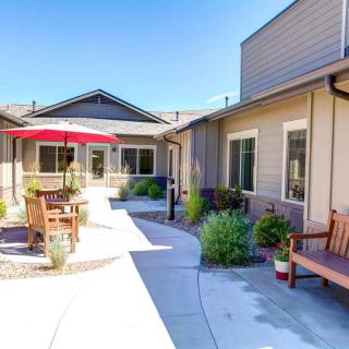 A bright courtyard with seating areas and potted plants under a clear blue sky.