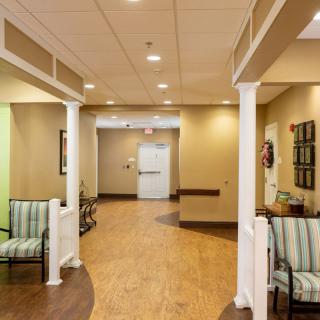 A warmly lit hallway with seating and decorative columns.