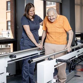 An elderly person receives assistance during a physical therapy session.