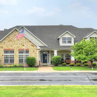 A suburban house with a well-maintained lawn and an American flag displayed outside.