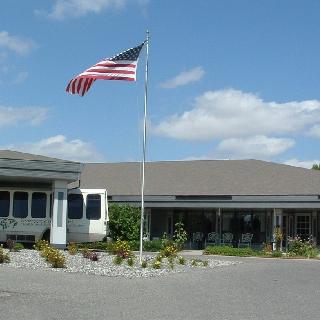 A sunny day at a building featuring the American flag proudly displayed.