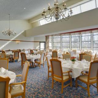 Elegant dining room with chandeliers and neatly set tables.