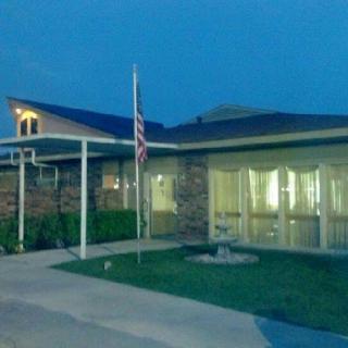 A view of a building at night, featuring an American flag and illuminated windows.