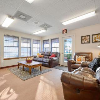 A cozy living room with comfortable seating, large windows, and decorative accents.