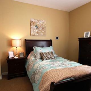 A cozy bedroom with a single bed, nightstand, and decorative elements.