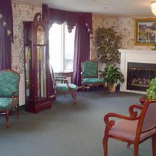 A cozy living room featuring a grandfather clock, fireplace, and elegant seating arrangement.