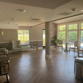 A modern waiting area with ample natural light streaming through large windows, featuring comfortable seating and a stylish interior design.