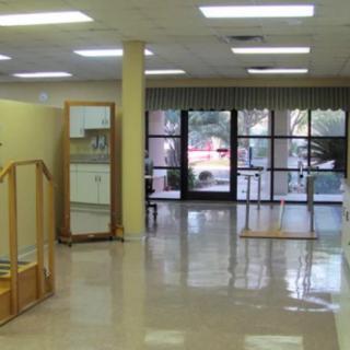 An empty storefront with large windows and polished flooring.