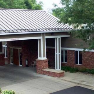 A building entrance with brick architecture and a covered driveway.