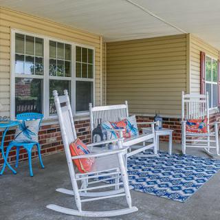 A cozy porch with rocking chairs and colorful decor.
