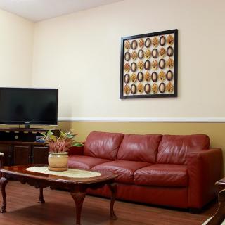 A cozy living room with a red sofa, television, and stylish decor.