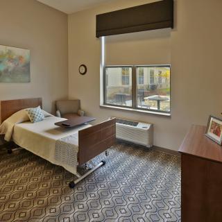 A cozy and well-lit bedroom with a single bed and modern furnishings.
