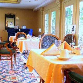 A cozy restaurant dining area with neatly set tables and large windows.