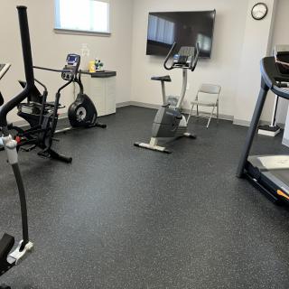 A modern indoor gym with various exercise equipment.