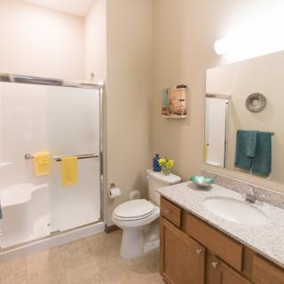 A clean and well-organized bathroom with a shower, toilet, and sink area.