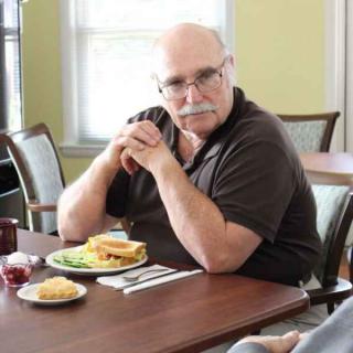 A man sitting at a table with a meal in front of him.