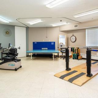 A well-equipped rehabilitation therapy room featuring various exercise machines and equipment.