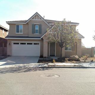 A two-story suburban house with a garage and driveway.