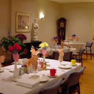 A well-decorated dining room with tables set for a patriotic-themed event.