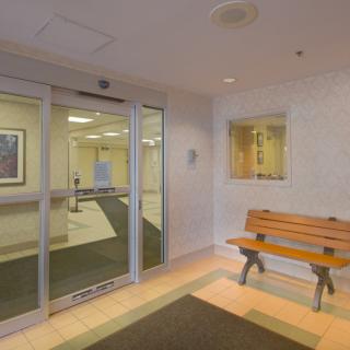 A small lobby area with a bench and glass entrance doors.
