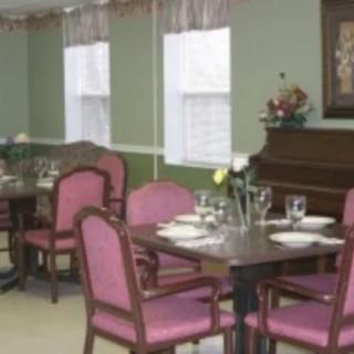 A cozy dining area with neatly set tables and a piano in the corner.