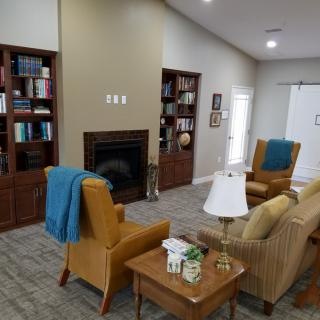 A cozy living room with bookshelves, a fireplace, and comfortable seating.
