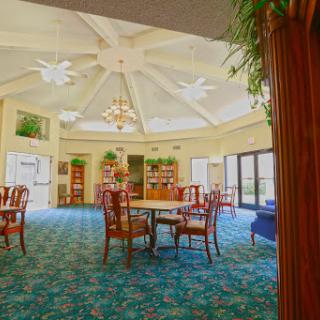 A spacious and well-lit lobby featuring elegant furniture and a decorative chandelier.