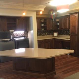 A spacious kitchen with wooden cabinets, a central island, and modern appliances.