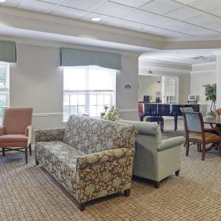 A cozy lounge area with sofas and armchairs arranged around a carpeted floor.