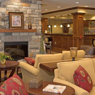 A cozy living room with a stone fireplace and comfortable seating.