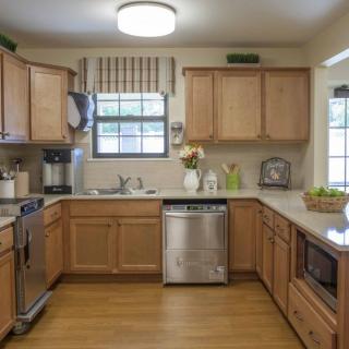 A cozy kitchen with wooden cabinets, modern appliances, and a bright window.