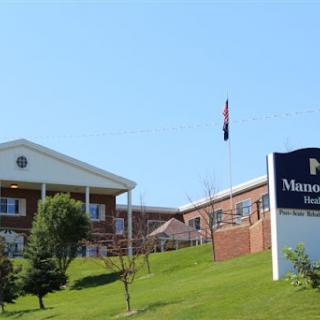 A healthcare facility with a prominent sign and flag under a clear blue sky.