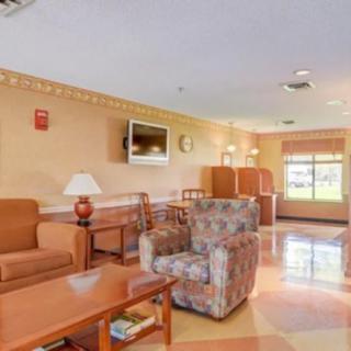 A cozy living room area with sofas, armchairs, and a television.