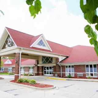 A welcoming exterior view of a building with a distinct red roof and modern architectural design.