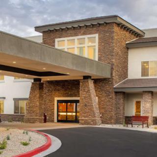A modern building featuring stonework and a covered entrance.