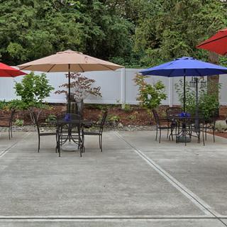 A quiet outdoor patio with tables and colorful umbrellas.