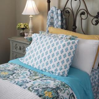 A cozy bedroom setup with a decorative pillow arrangement and stylish bedding.