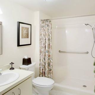 A clean and minimalist bathroom with a shower, toilet, and sink.