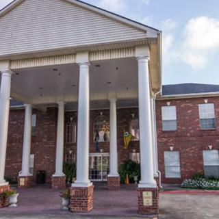 A classic building entrance with large white columns and a brick exterior.