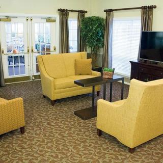 A cozy living room with yellow furniture and a large TV.