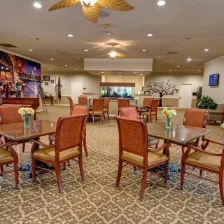 A spacious and elegantly decorated dining area with tables, chairs, and a patterned carpet.