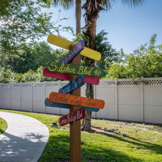 A colorful signpost with multiple directional signs in an outdoor setting.