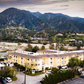 Aerial view of a residential building set against a mountainous landscape.