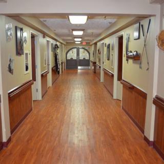 A clean and well-lit hallway with wooden flooring and decorated walls.