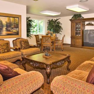 A cozy living room with warm-toned sofas, a central coffee table, and decorative plants creating an inviting atmosphere.