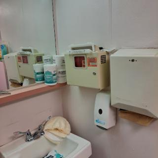 A view of a bathroom sink area with various hygiene products and amenities.